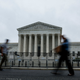 People walk past the U.S. Supreme Court Building during a rainstorm on June 23, 2022, in Washington, DC. Decisions are expected in 13 more cases before the end of the Court’s current session.